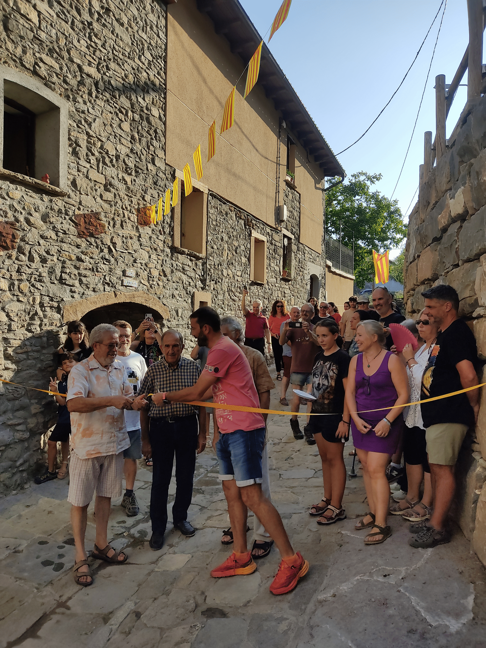 Villa de Ainsa - Sobrarbe Pirineo El alcalde cortando la cinta junto al presidente de los vecinos