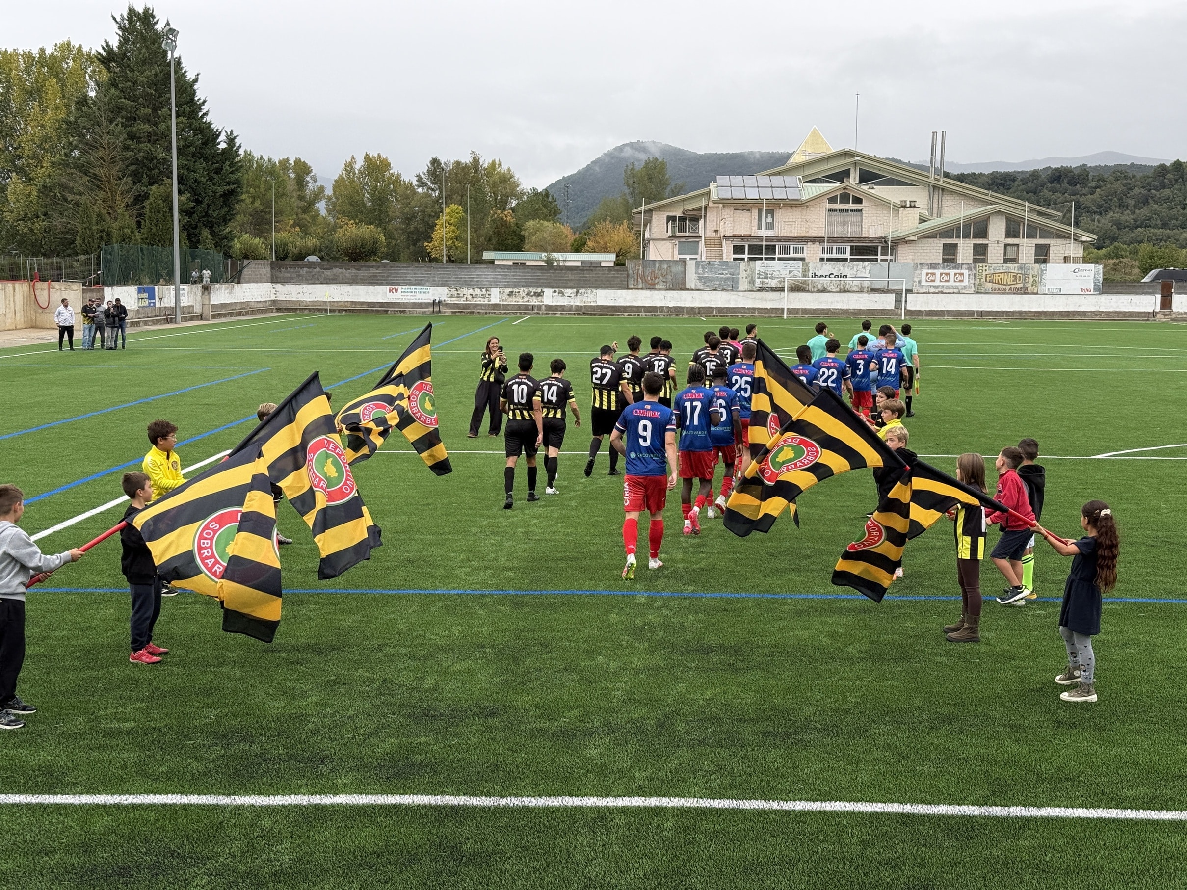 Villa de Ainsa - Sobrarbe Pirineo Aínsa estrena su campo de fútbol de césped artificial tras una inversión municipal de 622.000 euros y 45 años de historia 2 Villa de Ainsa - Sobrarbe Pirineo Entrada de los equipos al terreno de juego